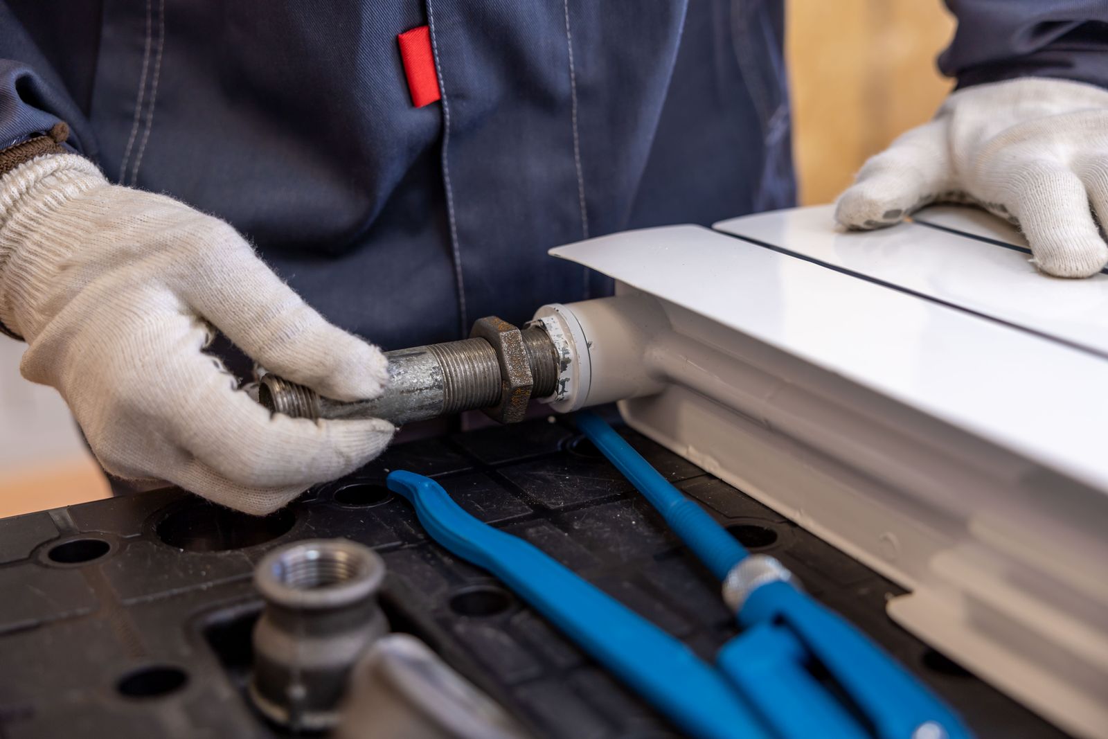 Monteur controleert de leidingaansluiting van een cv-radiator